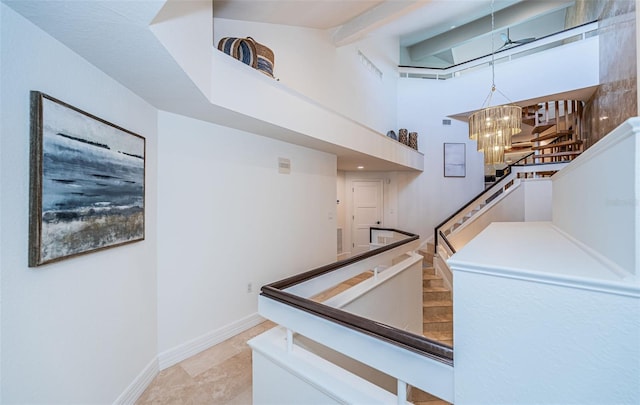 stairs featuring a high ceiling and a notable chandelier