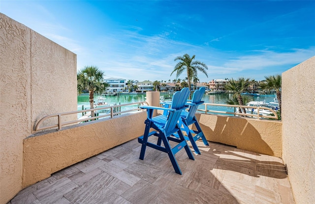 view of patio with a balcony and a water view