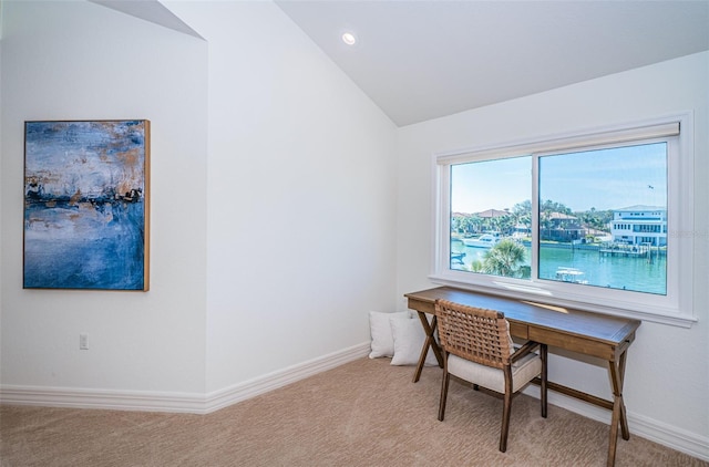 office area featuring light carpet, lofted ceiling, and a water view