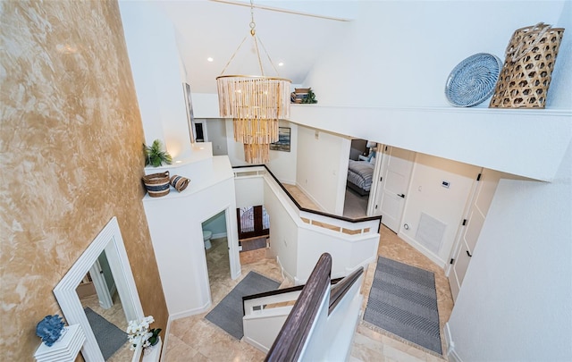 stairs featuring high vaulted ceiling and a notable chandelier