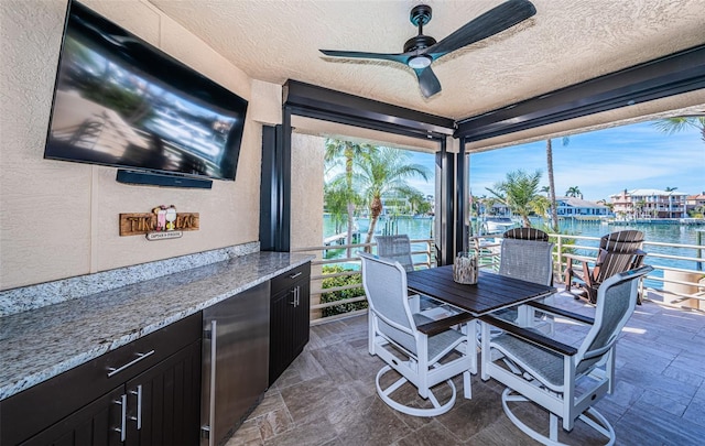 interior space featuring a water view and ceiling fan