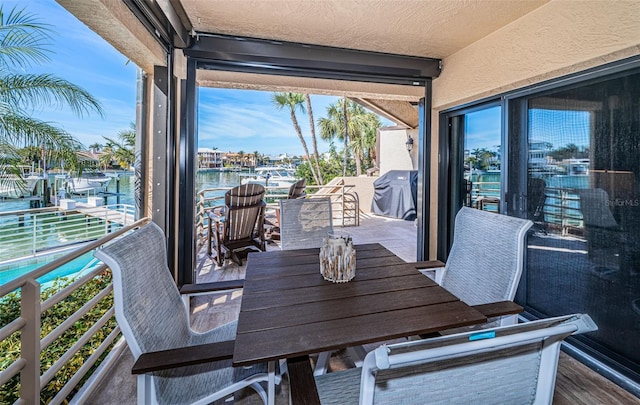 balcony with a water view and grilling area