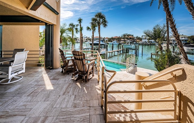 view of patio / terrace with a water view and a boat dock