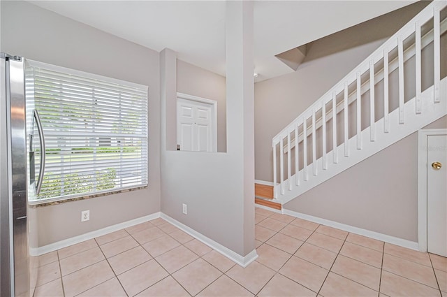 foyer featuring light tile patterned flooring and a healthy amount of sunlight