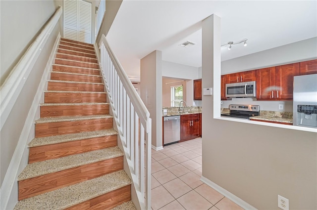 stairs with tile patterned floors and sink