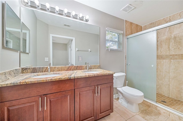 bathroom featuring tile patterned flooring, vanity, toilet, and walk in shower