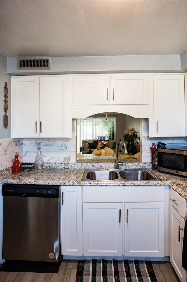 kitchen featuring white cabinets, sink, decorative backsplash, dark hardwood / wood-style flooring, and stainless steel appliances