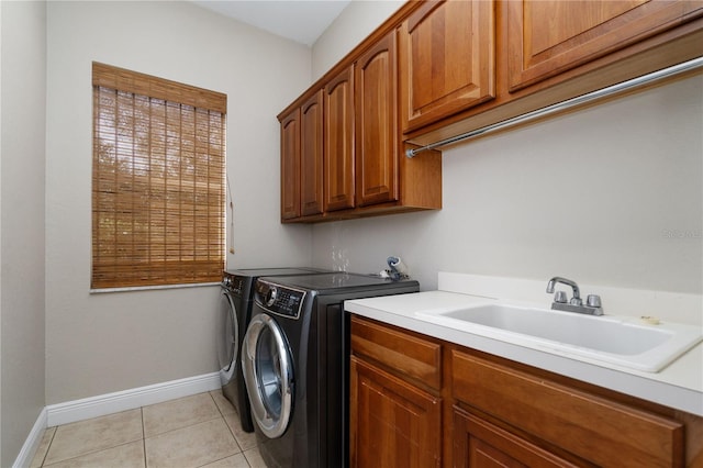 washroom with light tile patterned floors, sink, cabinets, and washing machine and clothes dryer