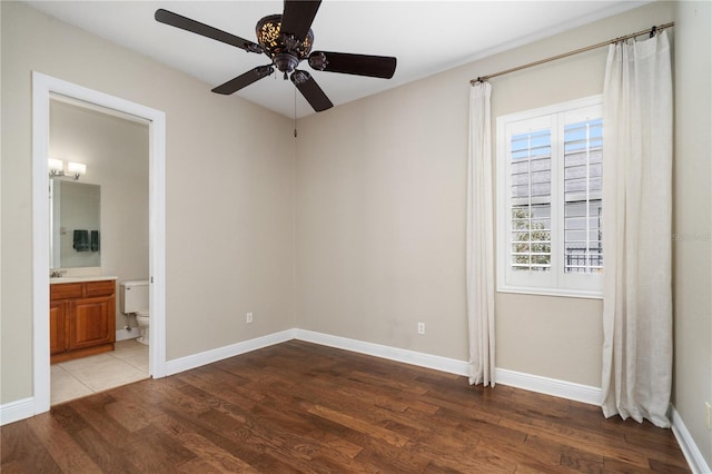 unfurnished bedroom with hardwood / wood-style flooring, ceiling fan, and connected bathroom