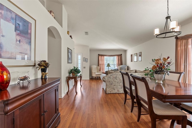 dining area with light hardwood / wood-style flooring and a chandelier