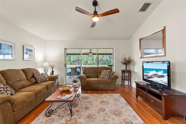 living room featuring vaulted ceiling, ceiling fan, and light wood-type flooring