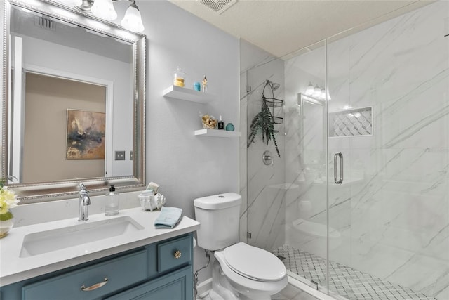 bathroom featuring vanity, a shower with shower door, and toilet