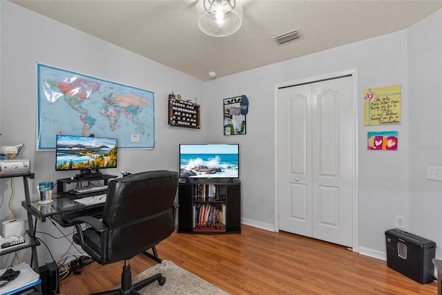 office space featuring light hardwood / wood-style floors and a textured ceiling