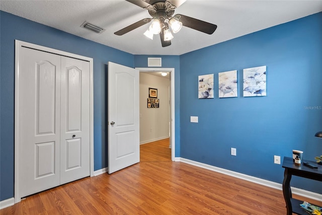 bedroom featuring ceiling fan, a closet, and light wood-type flooring