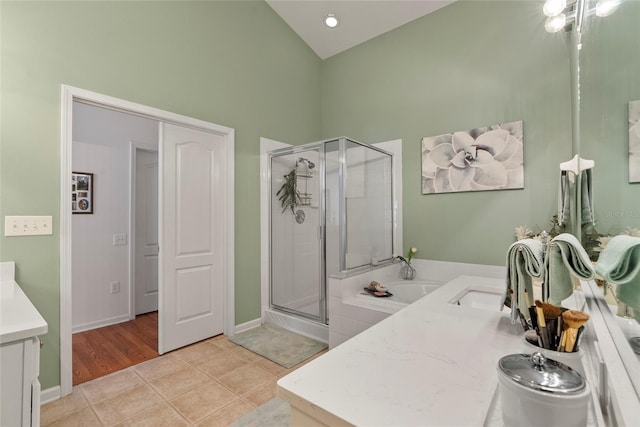 bathroom featuring lofted ceiling, tile patterned floors, separate shower and tub, and vanity