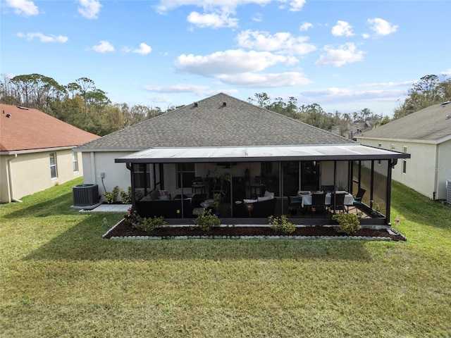 back of house featuring cooling unit, a sunroom, and a lawn