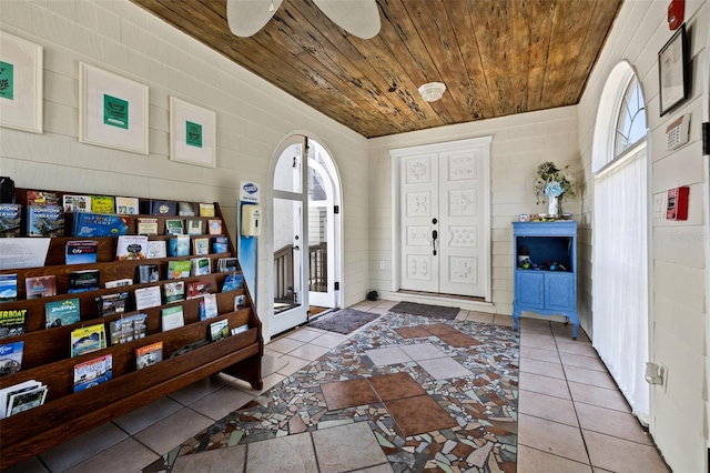 tiled foyer featuring ceiling fan and wooden ceiling