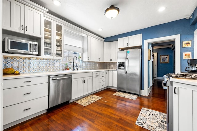 kitchen with backsplash, white cabinetry, sink, and appliances with stainless steel finishes