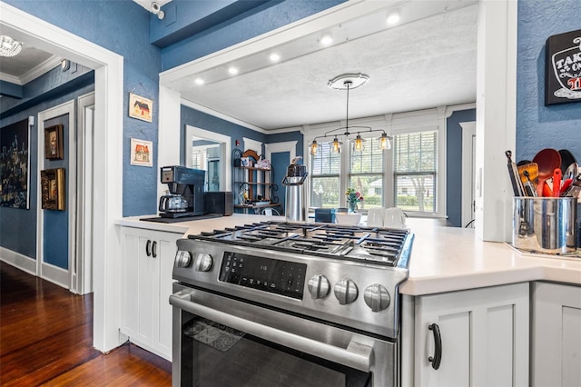 kitchen with gas range, white cabinetry, hanging light fixtures, and ornamental molding