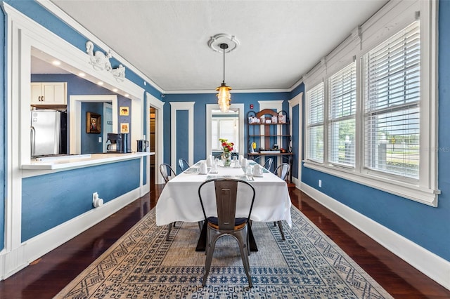 dining area with dark hardwood / wood-style flooring, a healthy amount of sunlight, and ornamental molding