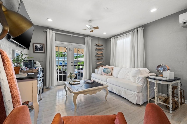 living room with french doors, light hardwood / wood-style flooring, ceiling fan, and an AC wall unit