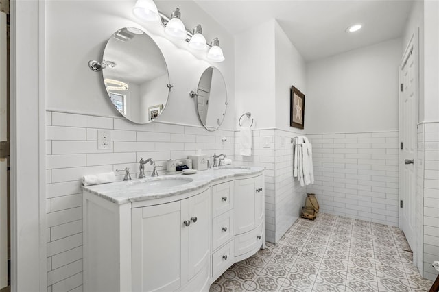 bathroom with tile patterned flooring, vanity, and tile walls