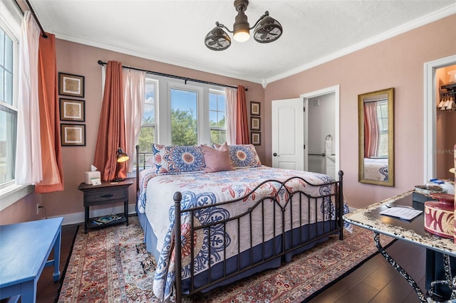 bedroom with ceiling fan, dark hardwood / wood-style flooring, crown molding, ensuite bathroom, and a textured ceiling