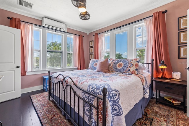 bedroom with dark hardwood / wood-style floors, ornamental molding, a wall unit AC, and multiple windows