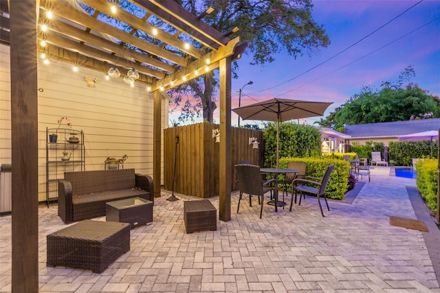 patio terrace at dusk with an outdoor hangout area and a pergola