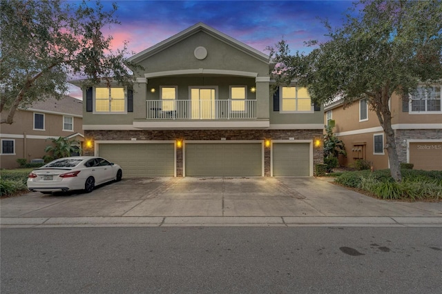 view of front facade featuring a garage and a balcony