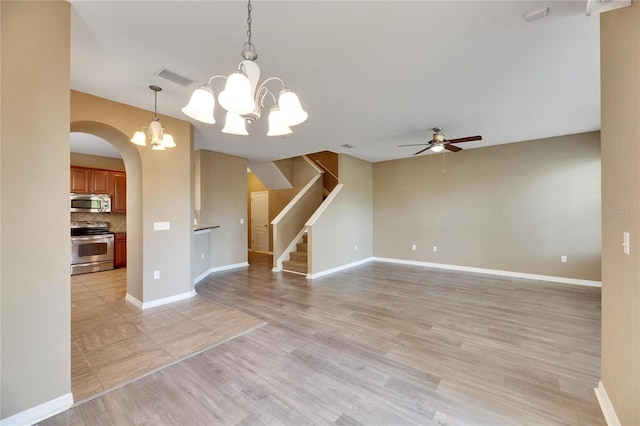 unfurnished living room featuring light hardwood / wood-style floors and ceiling fan with notable chandelier