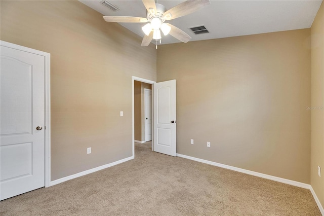 carpeted spare room featuring a high ceiling and ceiling fan