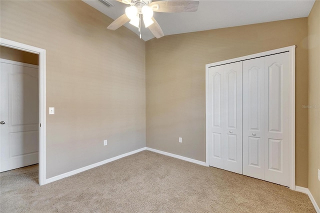 unfurnished bedroom with a closet, light colored carpet, ceiling fan, and lofted ceiling