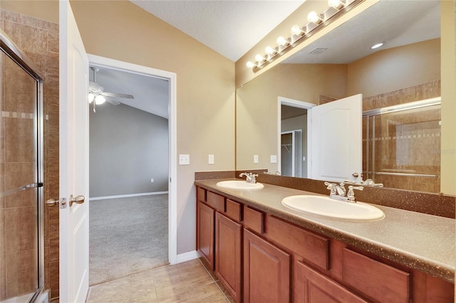 bathroom featuring ceiling fan, a shower with shower door, lofted ceiling, and vanity