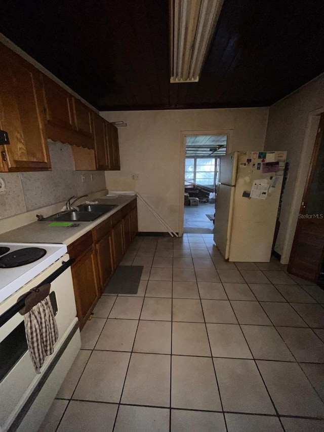 kitchen with tasteful backsplash, sink, light tile patterned flooring, and white appliances