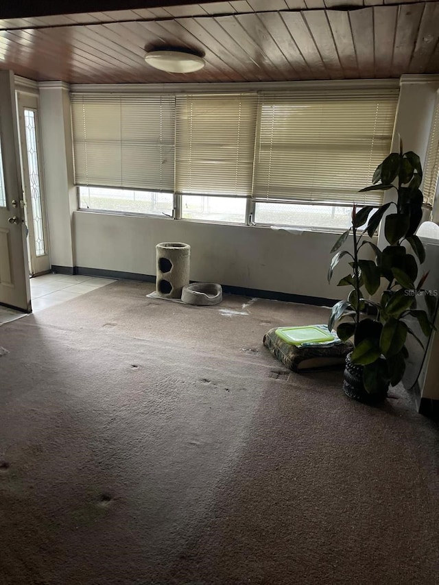 empty room with light colored carpet and wooden ceiling