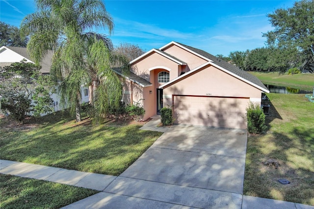 view of front facade featuring a water view, a garage, and a front lawn