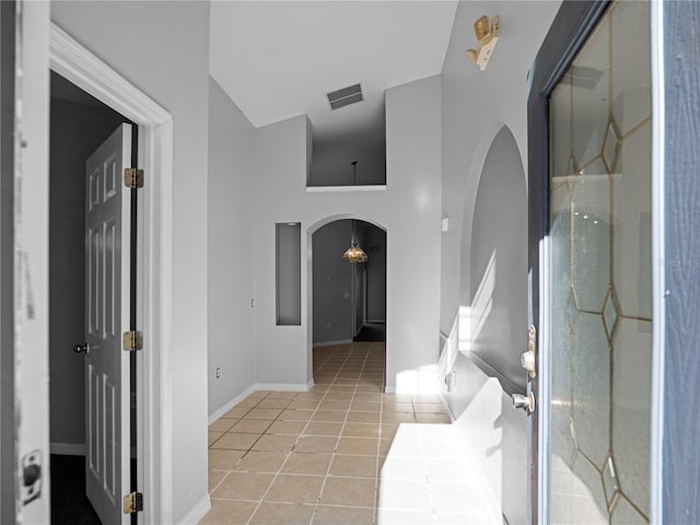 interior space with light tile patterned floors and a high ceiling