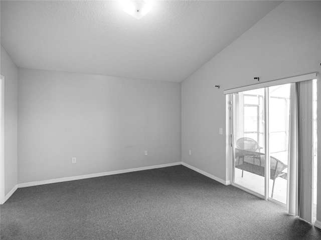 spare room with a textured ceiling, carpet floors, and lofted ceiling