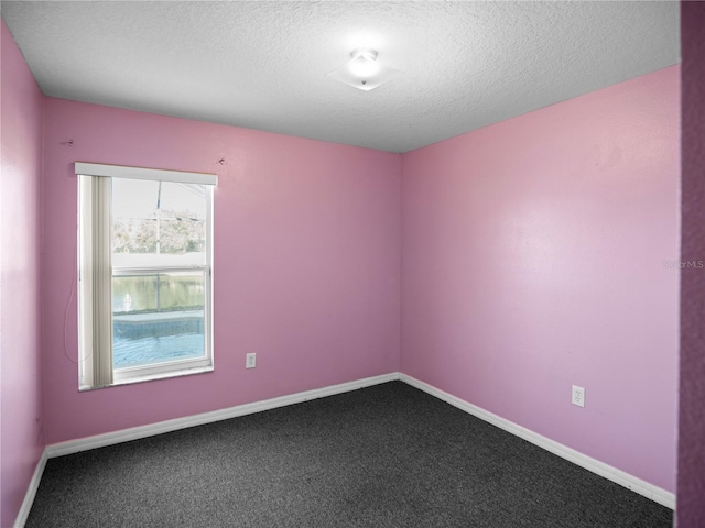 carpeted spare room with a textured ceiling