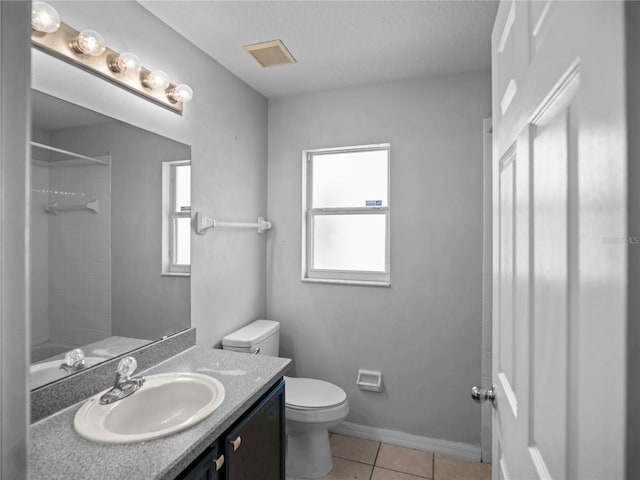 bathroom with tile patterned floors, vanity, a textured ceiling, a shower, and toilet