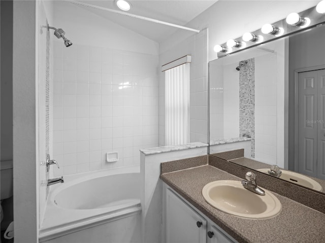 bathroom featuring vanity, bathing tub / shower combination, and vaulted ceiling