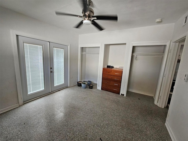 unfurnished bedroom featuring two closets, ceiling fan, and french doors