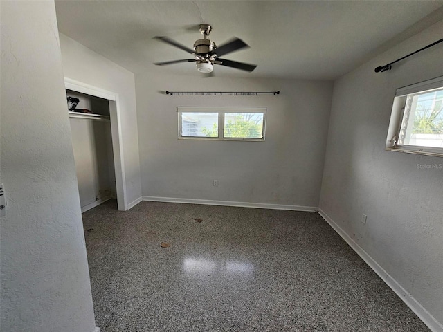 unfurnished bedroom with ceiling fan and a closet