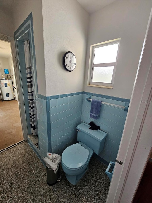 bathroom with tile walls, electric water heater, toilet, and a shower with shower curtain