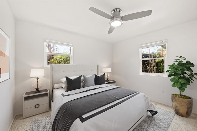 bedroom featuring multiple windows, light speckled floor, and ceiling fan