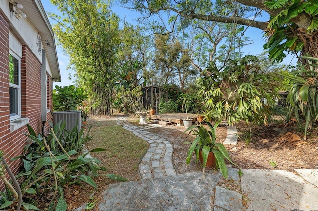 view of yard featuring a garden and central AC