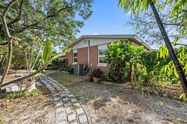 view of home's exterior featuring brick siding and central AC unit