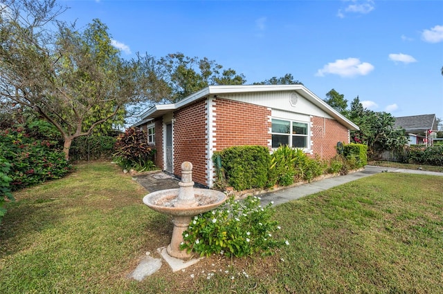 view of property exterior with a yard and brick siding