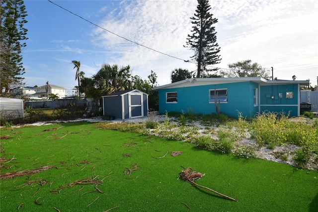 rear view of property featuring a yard and a shed